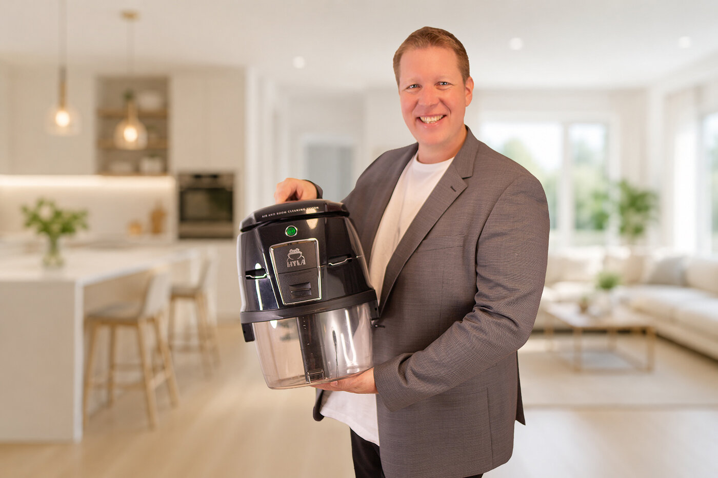 Christian Staffler mit dem HYLA Wasserfiltersystem in einem hellen Wohnzimmer